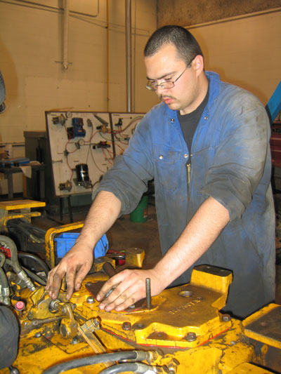 Grade 12 student repairing a hydraulic hose