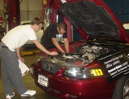 two grade twelve students preforming a charging system diagnostic